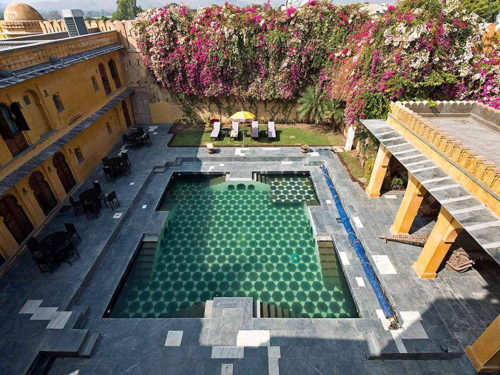 Enjoy a romantic drink by the pool at one of the best resorts near Delhi